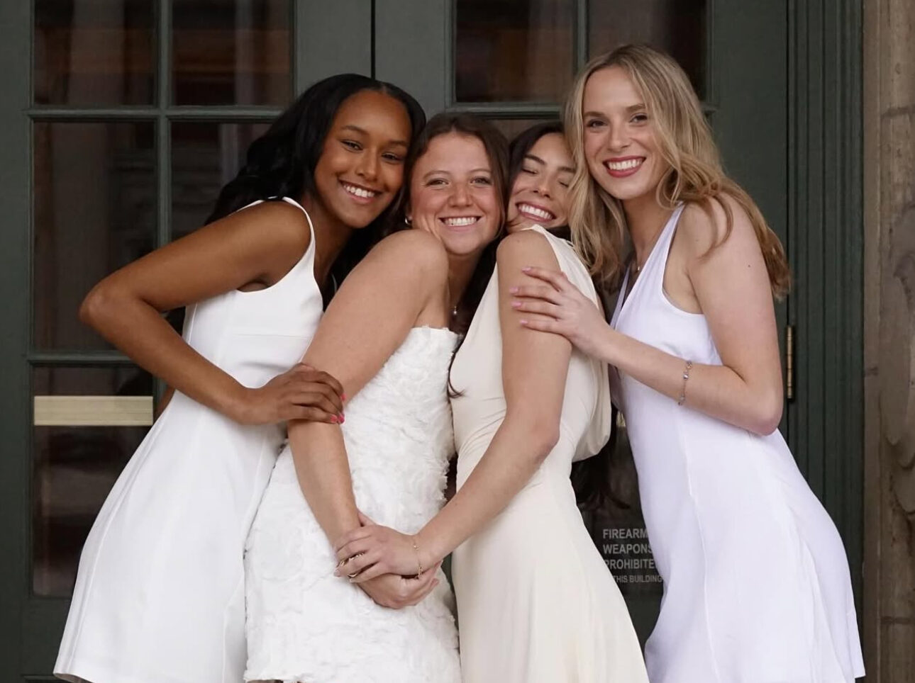 Four members wearing white hugging