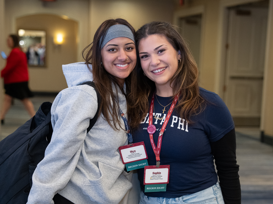 Two Pi Phis posing at a Pi Phi event