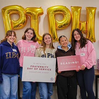Five Pi Phi collegians holding signs that read Fraternity Day of Service